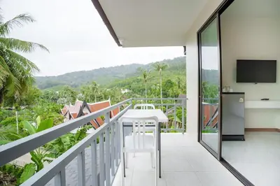 a balcony with a white table and a television at 1 bedroom apartment - 2 min to the Nai Harn beach in Rawai Beach
