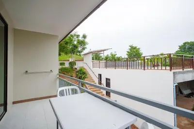 a balcony with a white table and a railing at 1 bedroom apartment - 2 min to the Nai Harn beach in Rawai Beach