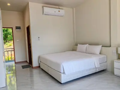 a bedroom with a white bed and a air conditioner at 1 bedroom apartment - 2 min to the Nai Harn beach in Rawai Beach