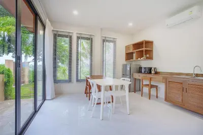 a kitchen with a table and chairs in a room at 1 bd Villa - 2 minutes to the Nai Harn beach A101, A102 in Rawai Beach