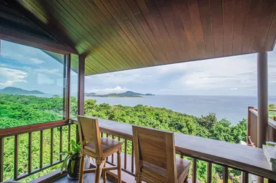 a balcony with two chairs and a view of the ocean at Bell Seaside Residence in Rawai Beach