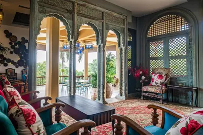 a living room with a table and a chair at Bell Seaside Residence in Rawai Beach