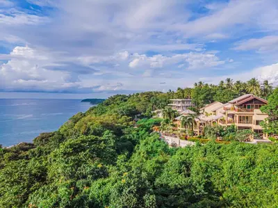 an aerial view of a house on a hill next to the ocean at Bell Seaside Residence in Rawai Beach