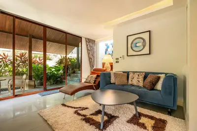 a living room with a blue couch and a table at Bell Seaside Residence in Rawai Beach