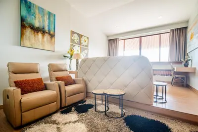 a living room with a couch and a chair and a table at Bell Seaside Residence in Rawai Beach