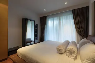 a bedroom with a large bed with pillows and a window at Apartment 100 м2, Naithon beach in Phuket
