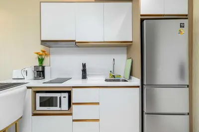 a kitchen with white cabinets and a refrigerator at C261 Work Play & Stay City 1BR Condo Poo l& Gym in Kathu