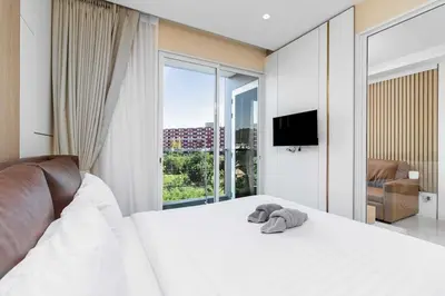 a bedroom with a white bed and a large window at C261 Work Play & Stay City 1BR Condo Poo l& Gym in Kathu