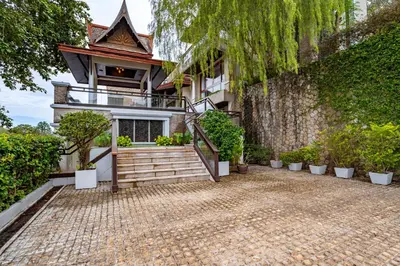 a house with a staircase in front of a building at Royal Legacy Golf Private Villa in Rawai Beach