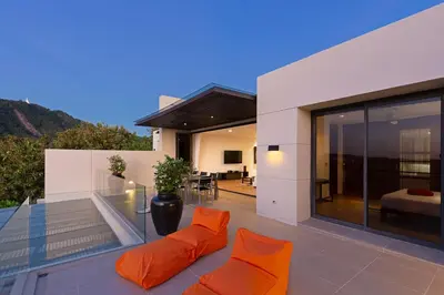 a living room with orange pillows on the balcony of a house at The Heights C3 SeaView 2 BR, 5min to Kata Beach in Ban Karon