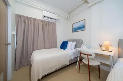 a bedroom with two beds and a table and a desk at Spacious 8 Bedroom 20 Person Near Patong Beach in Patong Beach