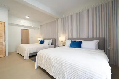 a bedroom with two beds with white and blue pillows at Spacious 8 Bedroom 20 Person Near Patong Beach in Patong Beach