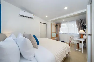 a bedroom with a white bed with white pillows at Spacious 8 Bedroom 20 Person Near Patong Beach in Patong Beach