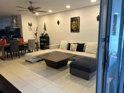 a living room with a couch and a table at Bangtao Beach Gardens 2 bedroom villa near Surin beach in Ban Lum Fuang