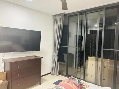 a living room with a flat screen tv and a dresser at Bangtao Beach Gardens 2 bedroom villa near Surin beach in Ban Lum Fuang