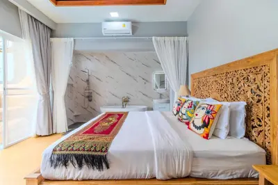 a bedroom with a large bed with white sheets and pillows at 10 bed,12 bath, 3 pools,zip-line,sauna, Ocean view in Ban Saiyuan (1)