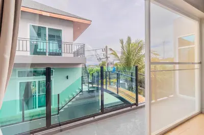 an open balcony with a view of a house at 10 bed,12 bath, 3 pools,zip-line,sauna, Ocean view in Ban Saiyuan (1)
