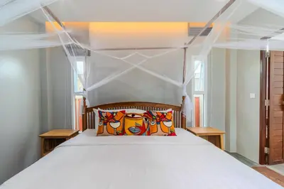 a large white bed with a wooden head board at 10 bed,12 bath, 3 pools,zip-line,sauna, Ocean view in Ban Saiyuan (1)