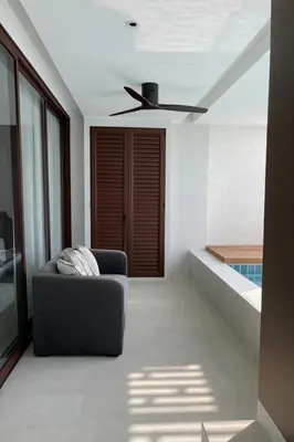 a living room with a couch and a ceiling fan at Апартаменты в Angsana, Банг Тао in Laguna Phuket