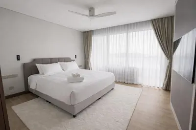 a bedroom with a white bed and a large window at Апартаменты в Angsana, Банг Тао in Laguna Phuket
