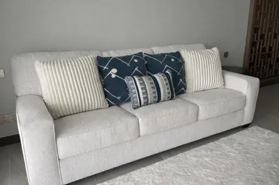a white couch with three pillows on it at Апартаменты в Angsana, Банг Тао in Laguna Phuket