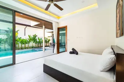 a bedroom with a bed and a swimming pool at Tropical 4 BR Pool Villa Mika in Rawai Beach