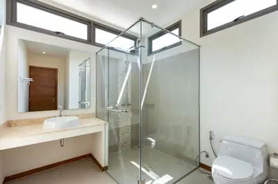a bathroom with a glass shower and a toilet at Tropical 4 BR Pool Villa Mika in Rawai Beach