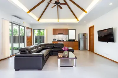 a living room with a leather couch and a table at Tropical 4 BR Pool Villa Mika in Rawai Beach