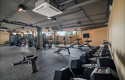 a gym with rows of exercise bikes and treadmills at Studio 50 meter from Layan Beach in Layan Beach