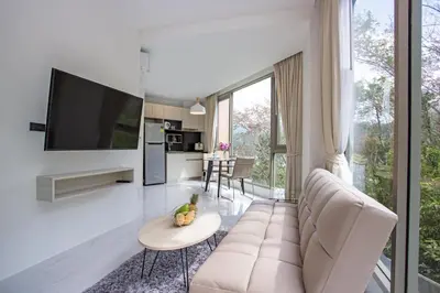 a living room with a couch and a tv at Oceana A32 1 BR Sea View - Kamala Beach in Kamala Beach
