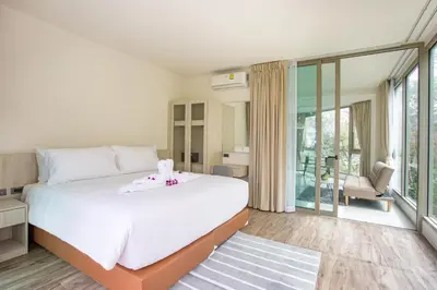 a bedroom with a large white bed and a balcony at Oceana A32 1 BR Sea View - Kamala Beach in Kamala Beach