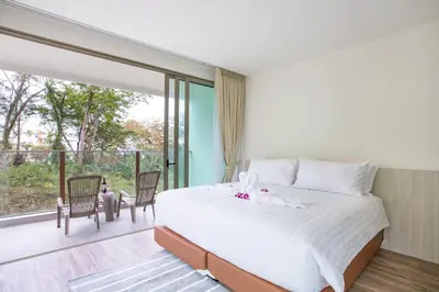 a bedroom with a large bed and a balcony at Oceana A32 1 BR Sea View - Kamala Beach in Kamala Beach