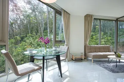 a living room with a glass table and chairs at Oceana A32 1 BR Sea View - Kamala Beach in Kamala Beach