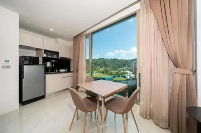 a kitchen and dining room with a table and a large window at Seaview 1BR Apt Oceana C36 near Kamala Beach in Kamala Beach