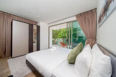 a bedroom with a white bed and a large window at Seaview 1BR Apt Oceana C36 near Kamala Beach in Kamala Beach