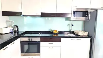 a kitchen with white cabinets and a sink at Phuket Apartment Kamala Regent Condo in Kamala Beach