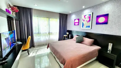 a bedroom with a bed and a flat screen tv at Phuket Apartment Kamala Regent Condo in Kamala Beach