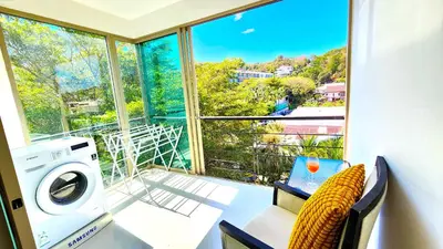 a room with a washing machine and a window at Phuket Apartment Kamala Regent Condo in Kamala Beach