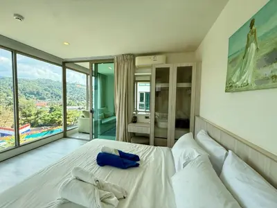 a bedroom with a large white bed with a large window at 1BR Panoramic Mountain View Walk to Beach by Renttini in Kamala Beach