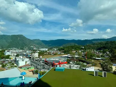 a view of a city with mountains in the background at 1BR Panoramic Mountain View Walk to Beach by Renttini in Kamala Beach