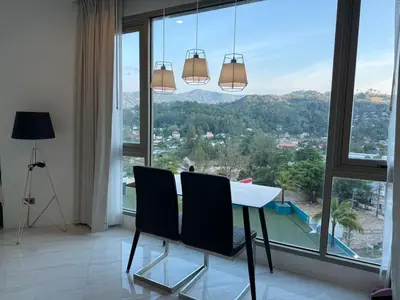 a dining room with a table and chairs in front of a window at 1BR Panoramic Mountain View Walk to Beach by Renttini in Kamala Beach
