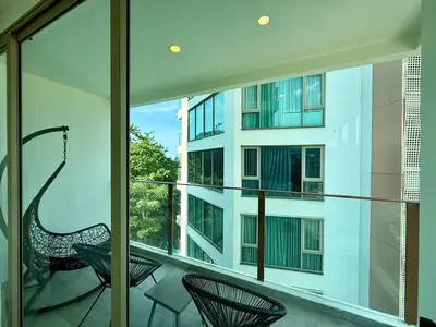 a balcony with two chairs and a building at 1BR Panoramic Mountain View Walk to Beach by Renttini in Kamala Beach