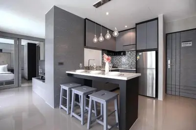a kitchen with a island with bar stools and a sink at Relax at CTG L702-3 - Kamala Health Complex in Kamala Beach