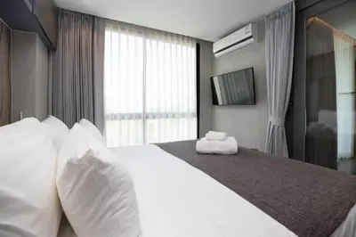 a bedroom with a large white bed with a window at Relax at CTG L702-3 - Kamala Health Complex in Kamala Beach