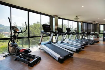 a row of cardio machines in a gym with windows at Relax at CTG L702-3 - Kamala Health Complex in Kamala Beach