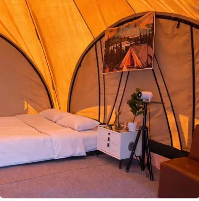 a bedroom with a tent with a bed and a lamp at Sireha Cafe Resort and Glamping in Ban Khok Chang