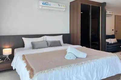 a large white bed with two pillows on top of it at Beach and Party in Patong with 1BR Apt - Viva B402 in Patong Beach