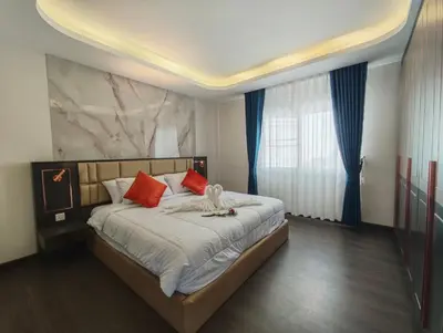 a bedroom with a large bed with red pillows at JJame Pool Villa Patong in Patong Beach
