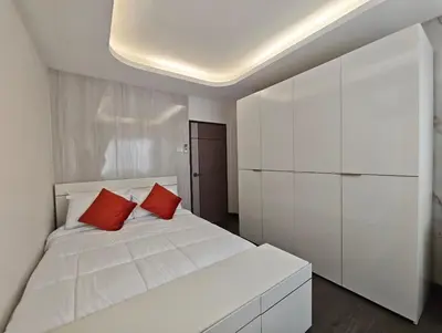a bedroom with a white bed with two red pillows at JJame Pool Villa Patong in Patong Beach