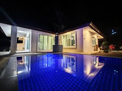 a swimming pool at night with a house at JJame Pool Villa Patong in Patong Beach